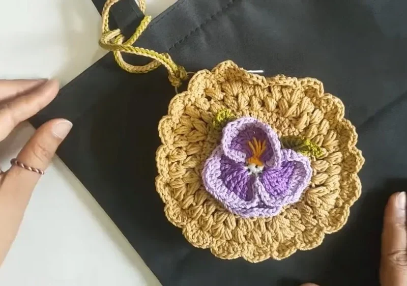 Round crochet wallet with a layered flower motif